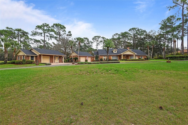 ranch-style home featuring a garage and a front lawn