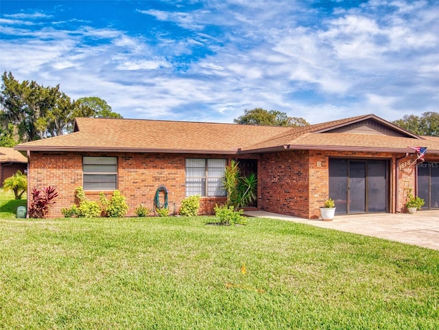 ranch-style house with a garage, brick siding, concrete driveway, and a front yard