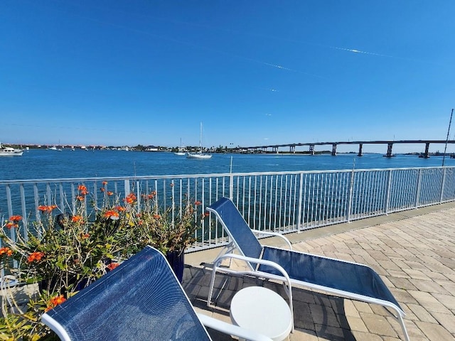 view of patio with a water view and a balcony