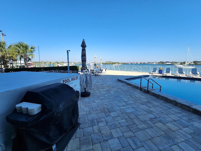 exterior space featuring a water view, a patio area, and a community pool