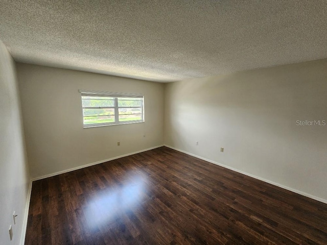 101 N Riverside Dr Unit 2090, New Smyrna Beach, FL 32168 - spare room featuring dark wood-type flooring, a textured ceiling, and baseboards