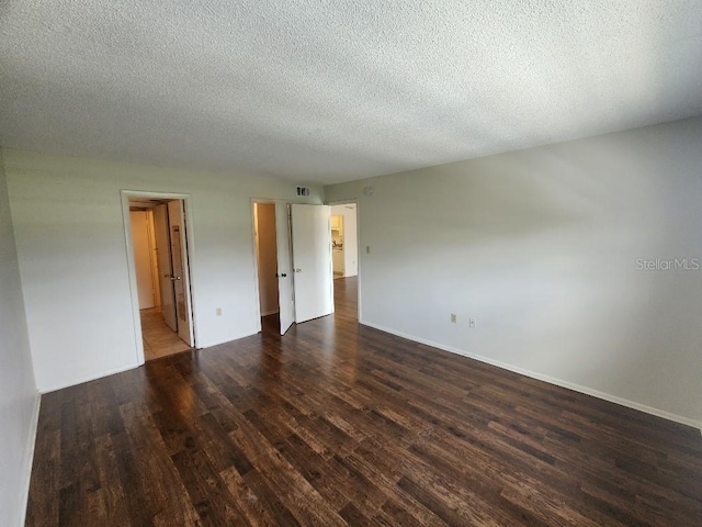 101 N Riverside Dr Unit 2090, New Smyrna Beach, FL 32168 - unfurnished room with dark wood-type flooring, baseboards, and a textured ceiling