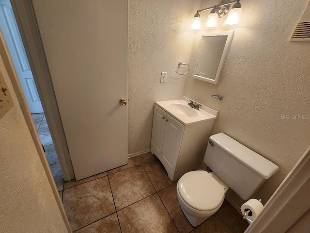 101 N Riverside Dr Unit 2090, New Smyrna Beach, FL 32168 - bathroom with vanity, toilet, tile patterned flooring, a textured wall, and baseboards