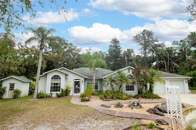2576 Shilo Glynn Ln, New Smyrna Beach, FL 32168 - ranch-style home with an attached garage, concrete driveway, stucco siding, a front yard, and view of wooded area