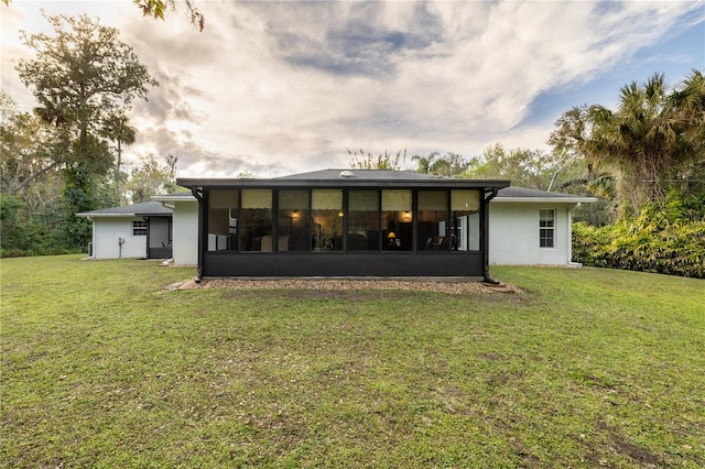 2576 Shilo Glynn Ln, New Smyrna Beach, FL 32168 - rear view of property featuring a sunroom, a yard, and stucco siding