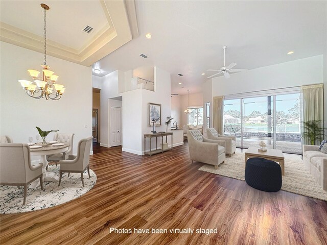 6456 Cypress Springs Pkwy, Port Orange, FL 32128 - living area with wood finished floors, visible vents, a high ceiling, a raised ceiling, and ceiling fan with notable chandelier