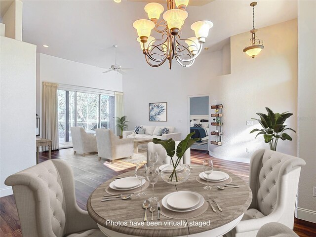 6456 Cypress Springs Pkwy, Port Orange, FL 32128 - dining space featuring baseboards, a high ceiling, wood finished floors, and ceiling fan with notable chandelier
