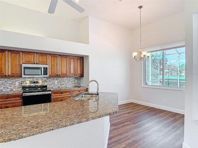 6456 Cypress Springs Pkwy, Port Orange, FL 32128 - kitchen featuring brown cabinets, a sink, stainless steel appliances, dark stone counters, and decorative backsplash
