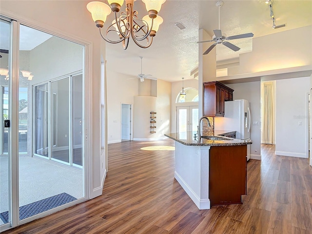 6456 Cypress Springs Pkwy, Port Orange, FL 32128 - kitchen featuring dark stone countertops, high vaulted ceiling, dark wood-style flooring, a sink, and ceiling fan with notable chandelier