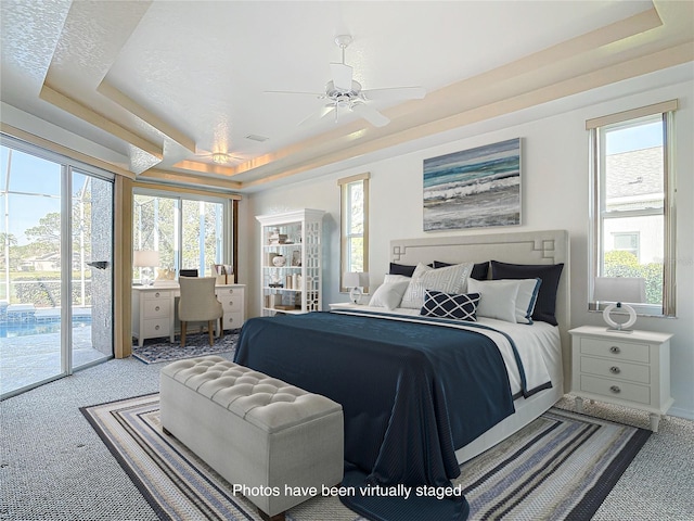 6456 Cypress Springs Pkwy, Port Orange, FL 32128 - carpeted bedroom featuring a tray ceiling, a ceiling fan, and access to outside