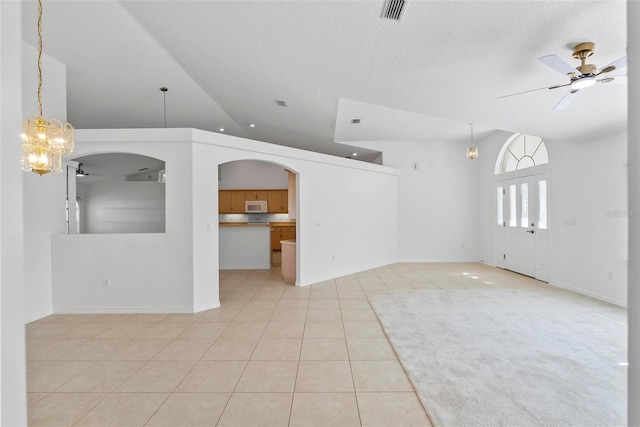 unfurnished room with light tile patterned floors, lofted ceiling, visible vents, ceiling fan, and a textured ceiling