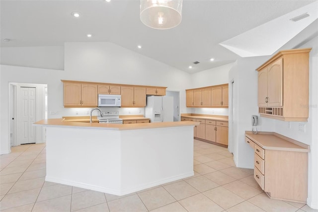 kitchen with light tile patterned flooring, white appliances, light countertops, light brown cabinetry, and a large island with sink