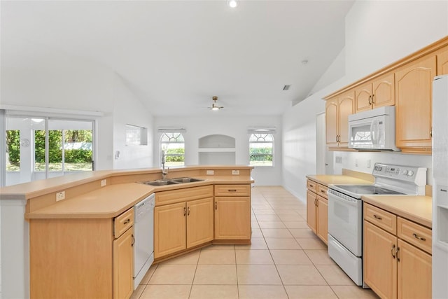 kitchen featuring light tile patterned flooring, white appliances, a sink, light countertops, and light brown cabinetry