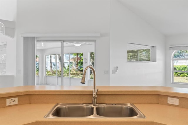 kitchen with lofted ceiling, light countertops, and a sink