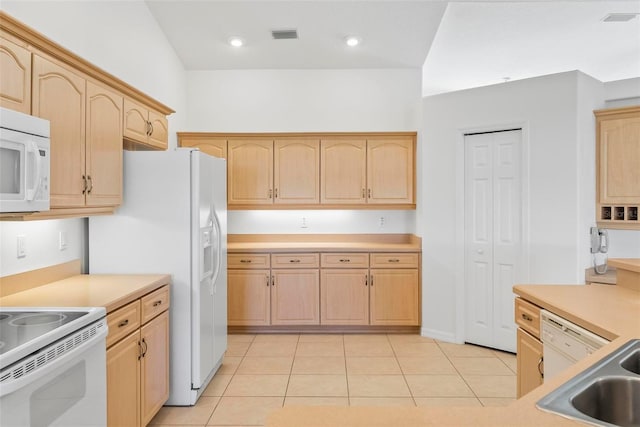 kitchen featuring white appliances, light brown cabinets, a sink, and visible vents