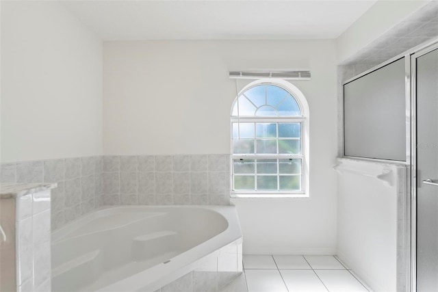 full bathroom featuring tile patterned flooring, a bath, and a shower stall