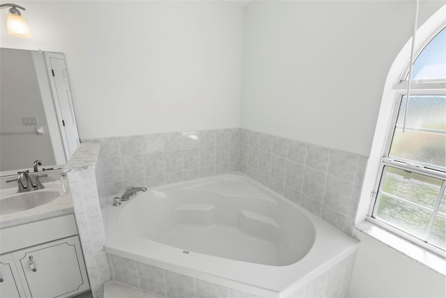 full bathroom featuring a bath and vanity