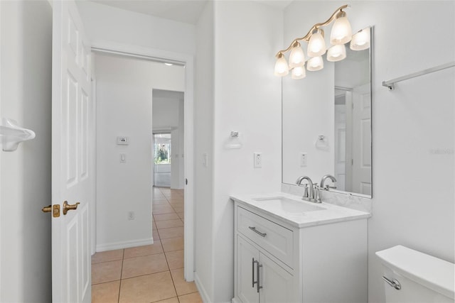 bathroom with toilet, tile patterned flooring, baseboards, and vanity