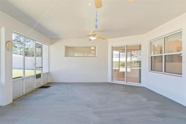 unfurnished sunroom with ceiling fan