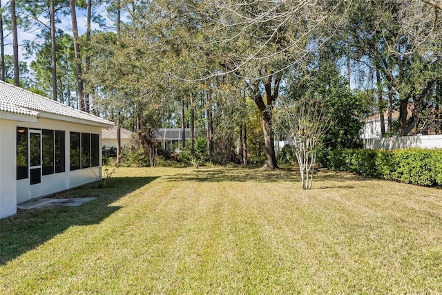 view of yard featuring a sunroom and fence