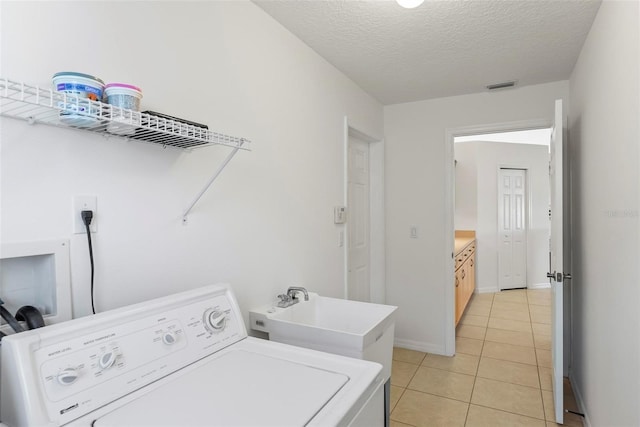 laundry area featuring washer hookup, light tile patterned floors, visible vents, a sink, and laundry area