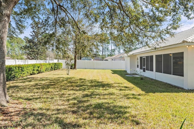 view of yard featuring a fenced backyard and a sunroom