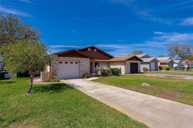 single story home with a front yard, stone siding, driveway, and an attached garage