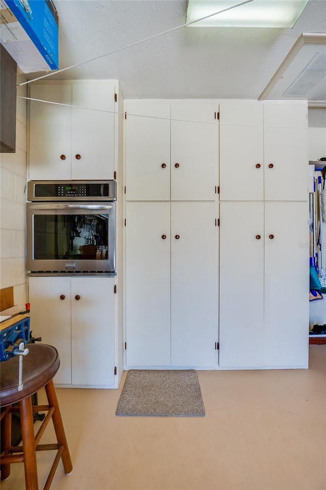 interior space featuring oven and white cabinetry