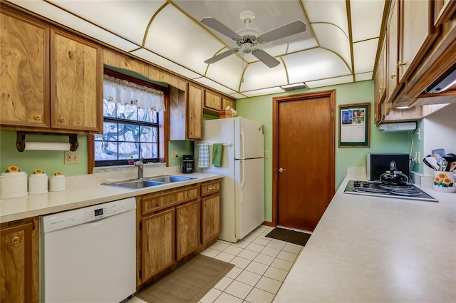 kitchen featuring white appliances, light countertops, and a sink