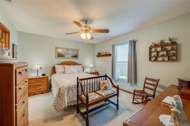 bedroom featuring ceiling fan, a textured ceiling, visible vents, and light colored carpet