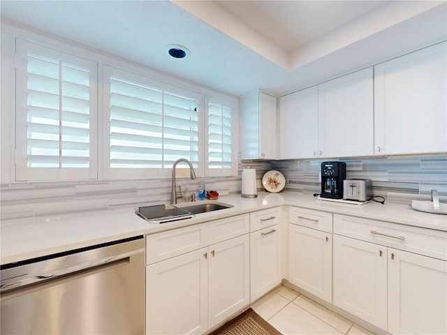 kitchen with light tile patterned floors, tasteful backsplash, white cabinets, a sink, and dishwasher