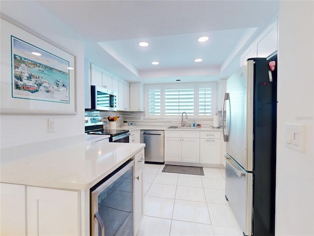 kitchen featuring wine cooler, stainless steel appliances, tasteful backsplash, light tile patterned flooring, and a sink