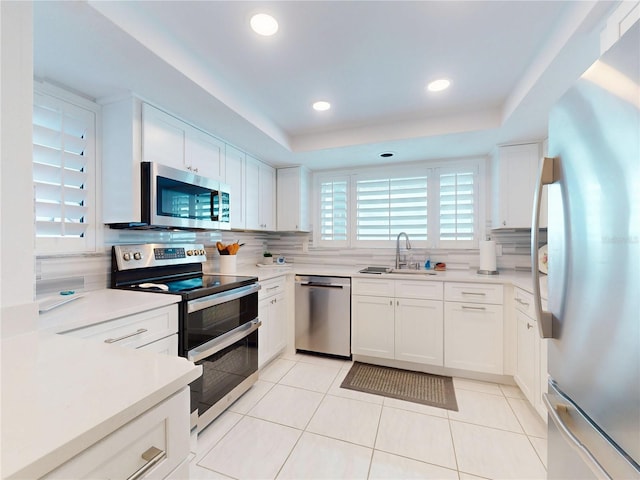 kitchen with backsplash, light tile patterned floors, stainless steel appliances, and a sink