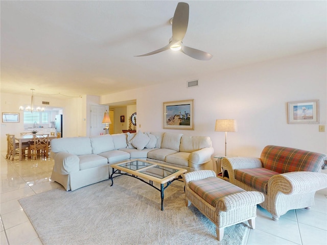 living room with ceiling fan with notable chandelier, visible vents, and light tile patterned flooring