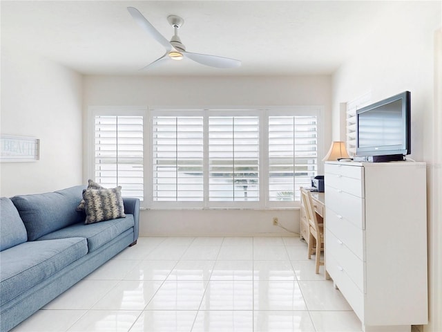 living area with a ceiling fan and light tile patterned floors