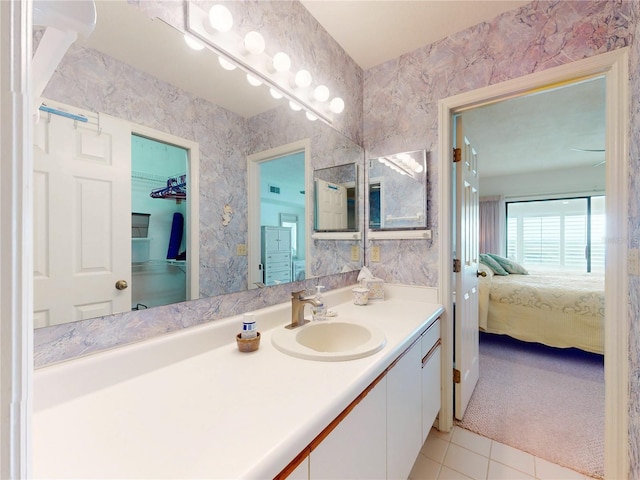 ensuite bathroom with wallpapered walls, vanity, connected bathroom, and tile patterned floors