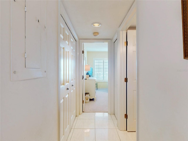 hall with light colored carpet and light tile patterned floors