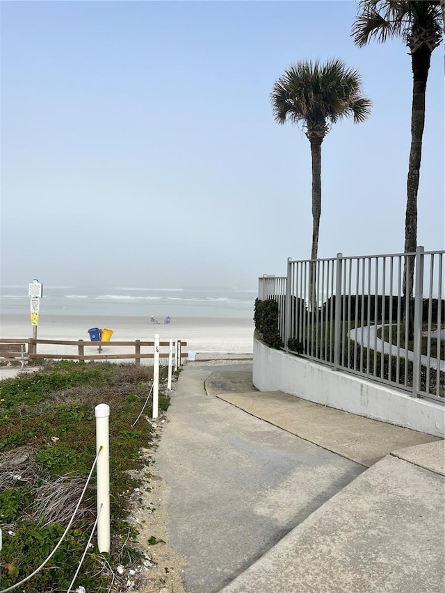 view of gate with a water view and fence