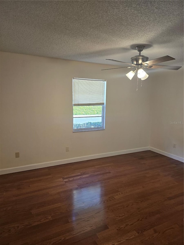 unfurnished room featuring ceiling fan, a textured ceiling, baseboards, and dark wood-type flooring