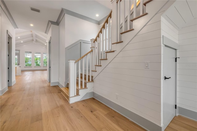 stairway with lofted ceiling, recessed lighting, visible vents, baseboards, and hardwood / wood-style floors