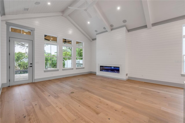 unfurnished living room with a glass covered fireplace, ceiling fan, high vaulted ceiling, light wood-type flooring, and beamed ceiling