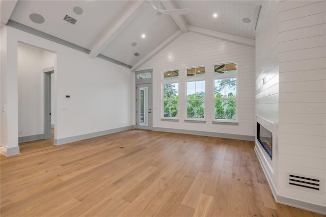 unfurnished living room with baseboards, visible vents, beamed ceiling, light wood-type flooring, and a fireplace