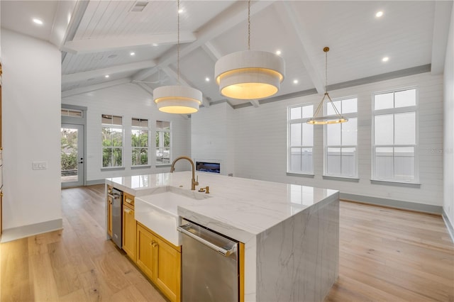 kitchen with a sink, light wood-type flooring, lofted ceiling with beams, and stainless steel dishwasher