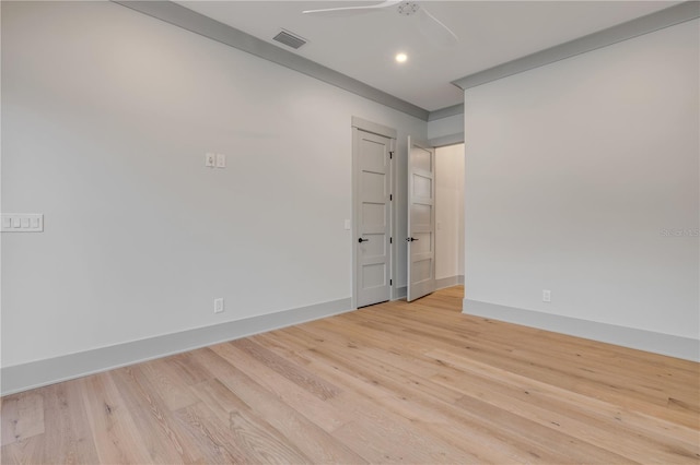 spare room featuring baseboards, ceiling fan, visible vents, and light wood-style floors