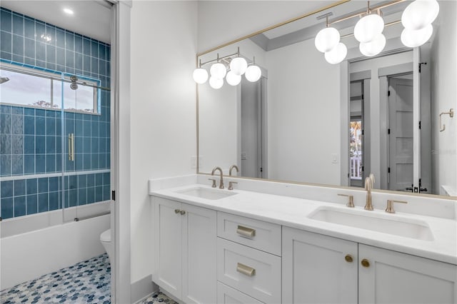 full bath featuring double vanity, bathing tub / shower combination, a sink, and toilet