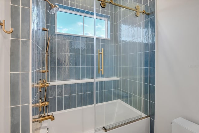 full bath featuring toilet and bath / shower combo with glass door