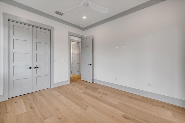 unfurnished bedroom featuring a ceiling fan, visible vents, baseboards, a closet, and light wood finished floors