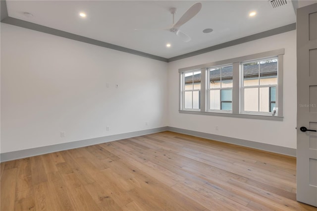 spare room with light wood-type flooring, visible vents, and baseboards