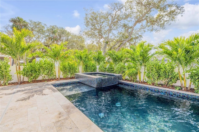 outdoor pool with fence, a patio, and an in ground hot tub