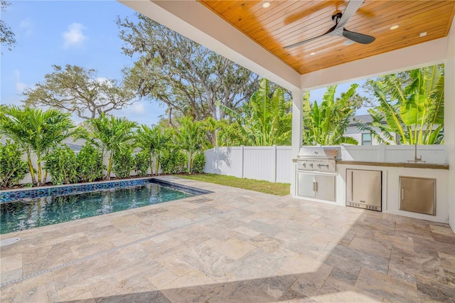 view of pool with ceiling fan, a patio, an outdoor kitchen, a fenced backyard, and area for grilling